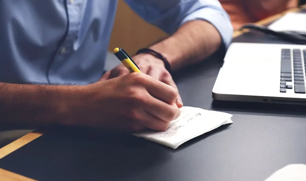man wrtitting in a paper